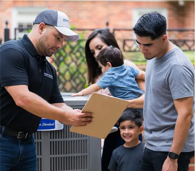 Delivery person handing package to family with children outdoors