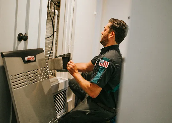 Technician in uniform checking HVAC system near water heater