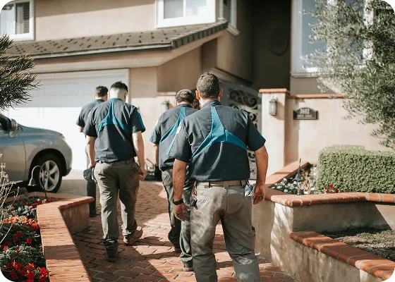 Law enforcement officers walking together towards a residential house