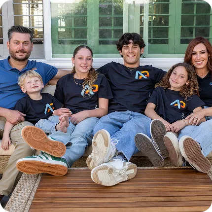 Family sitting together on bench, wearing matching logo t-shirts