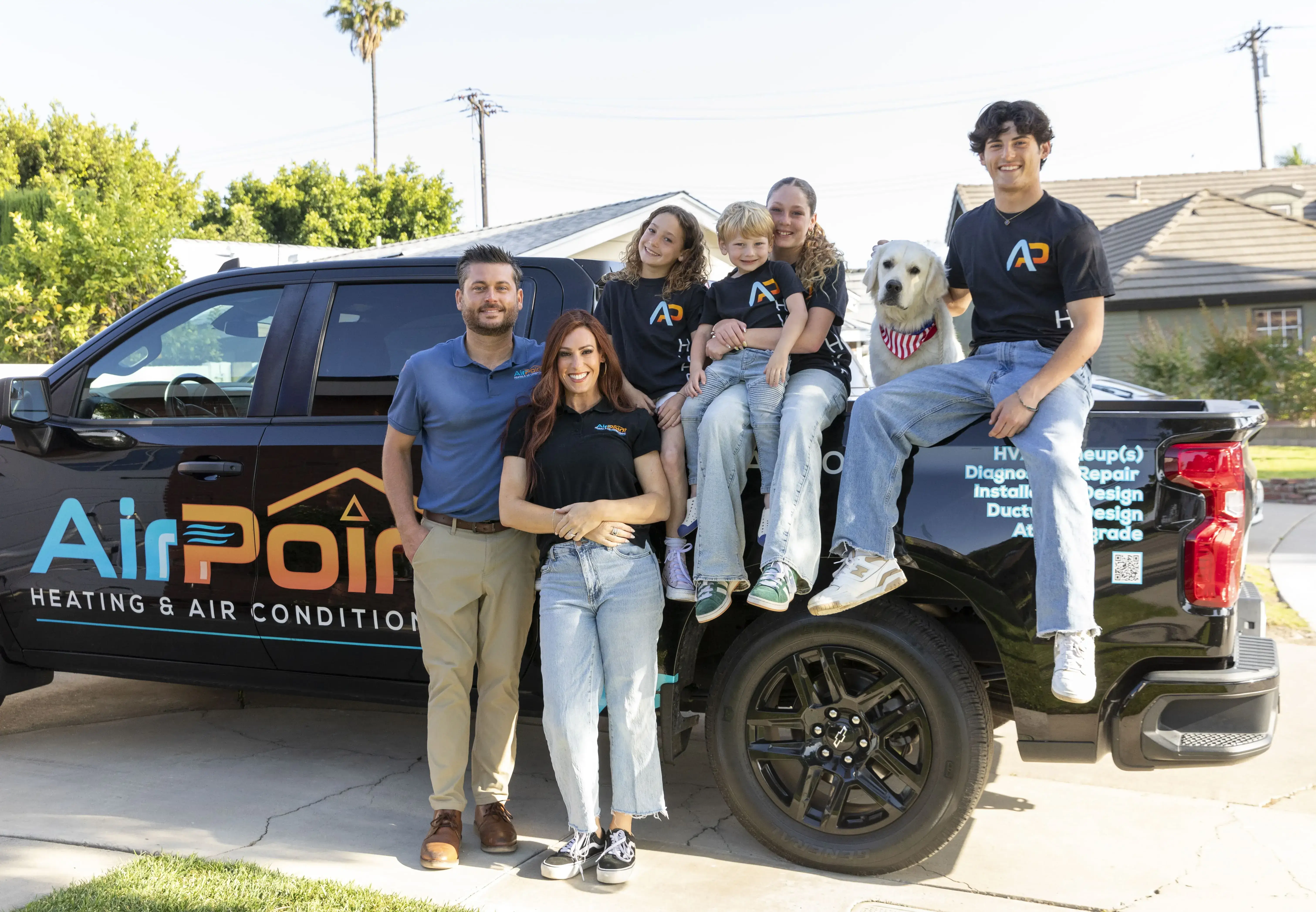 Family and team of AirPoint Heating & Air Conditioning posing with truck
