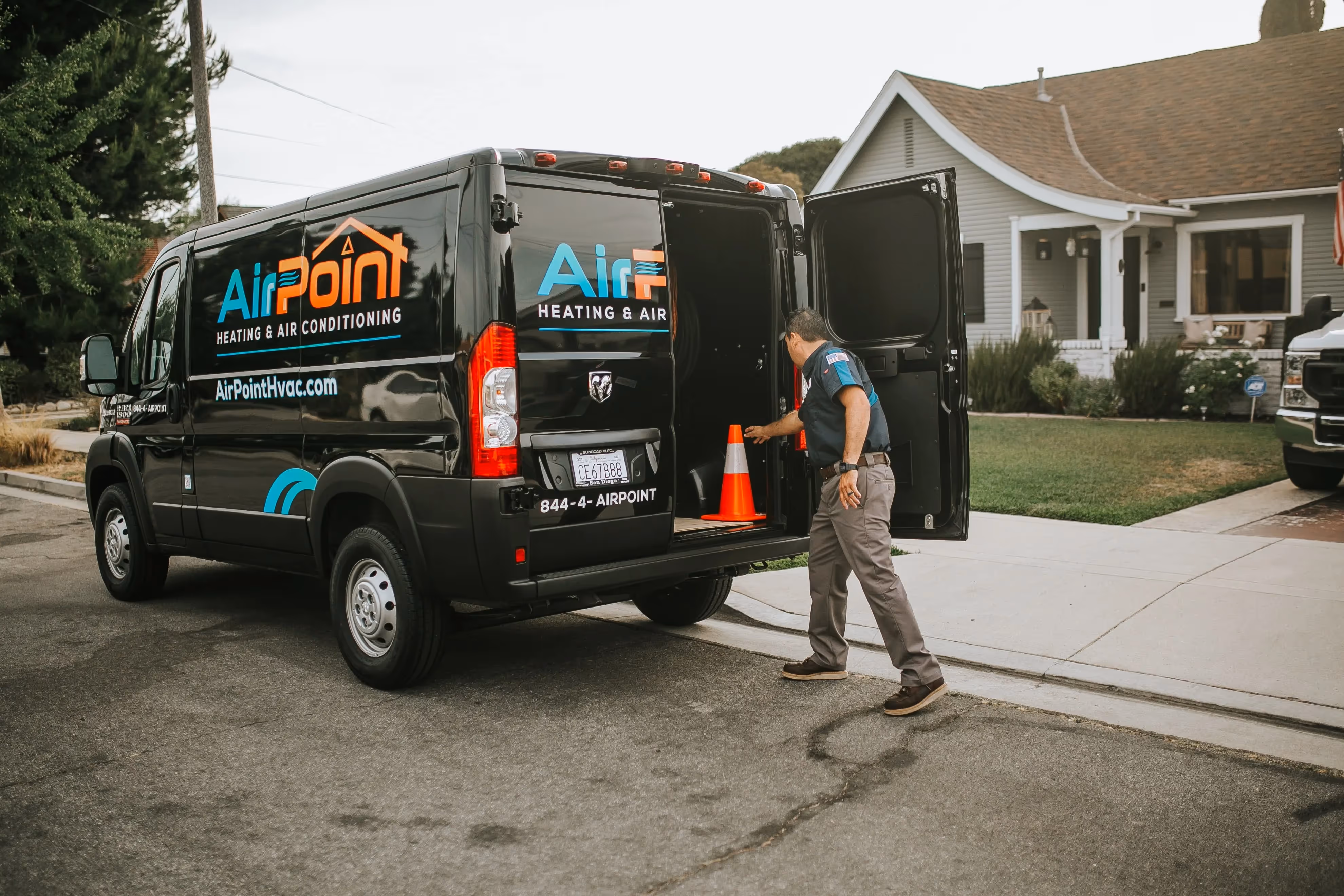 AirPoint HVAC service van parked on residential street with technician nearby