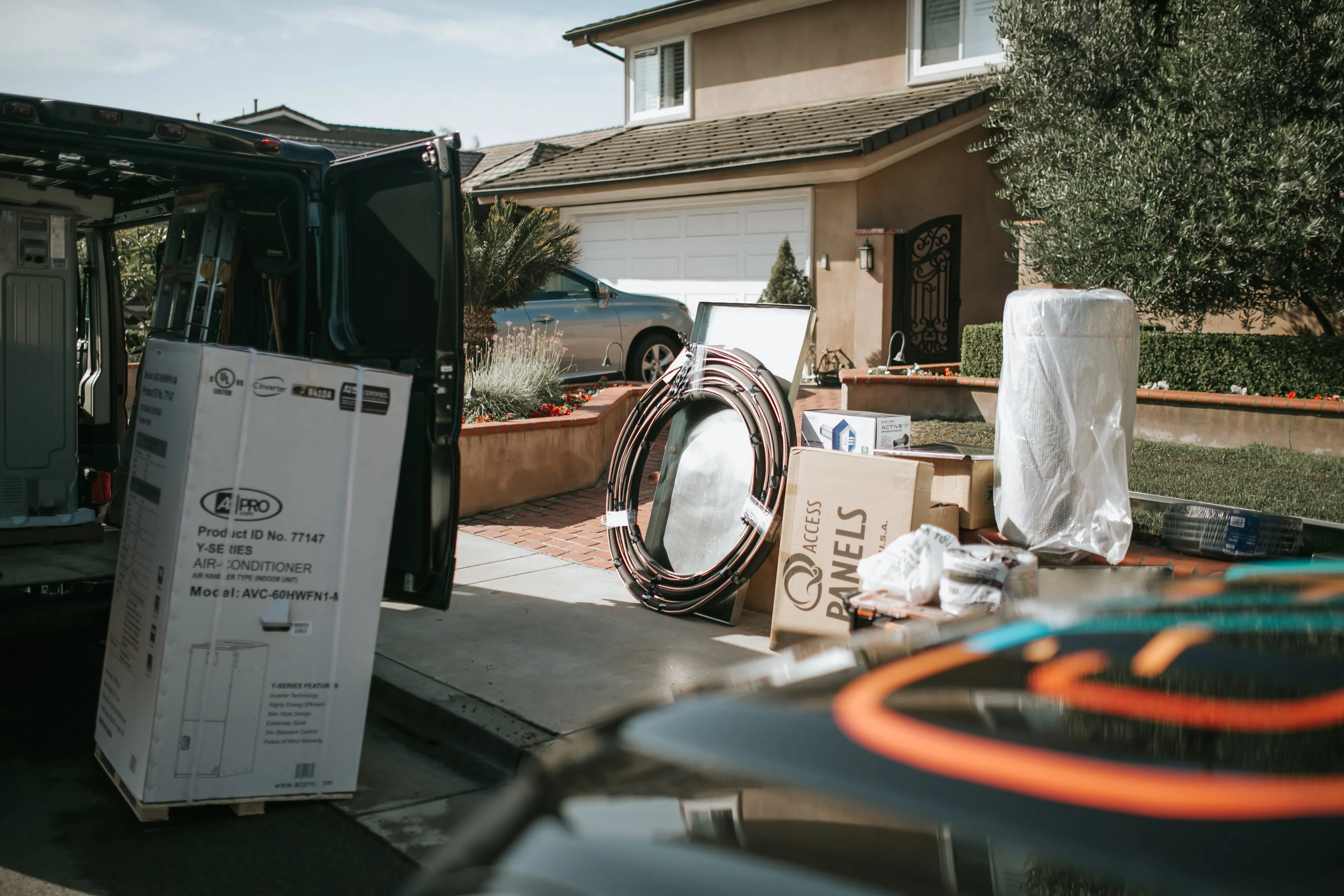 Air conditioner and installation materials near moving truck at residential home