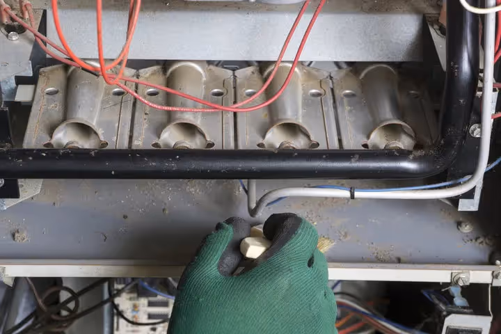 Gloved hand working on electrical components with red and white wires