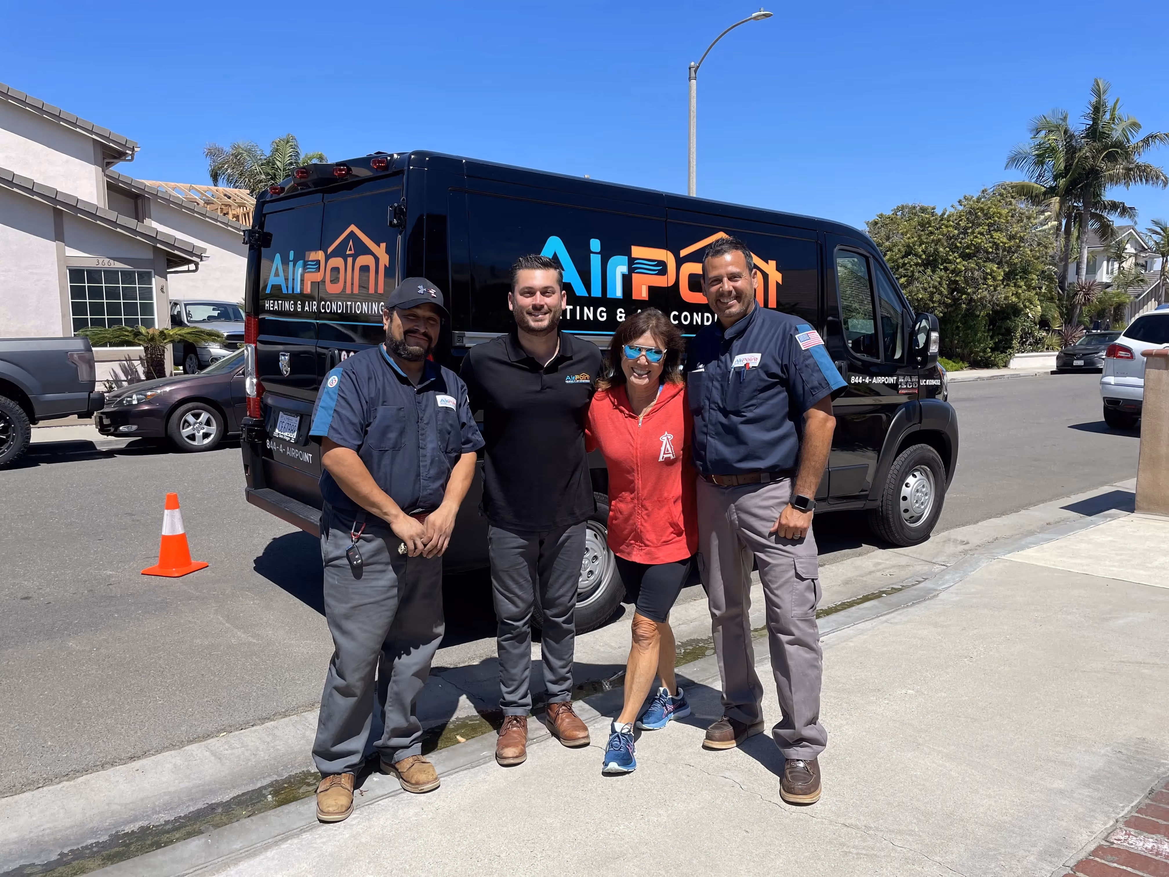 Four AirPoint Heating & Air Conditioning team members pose by service van