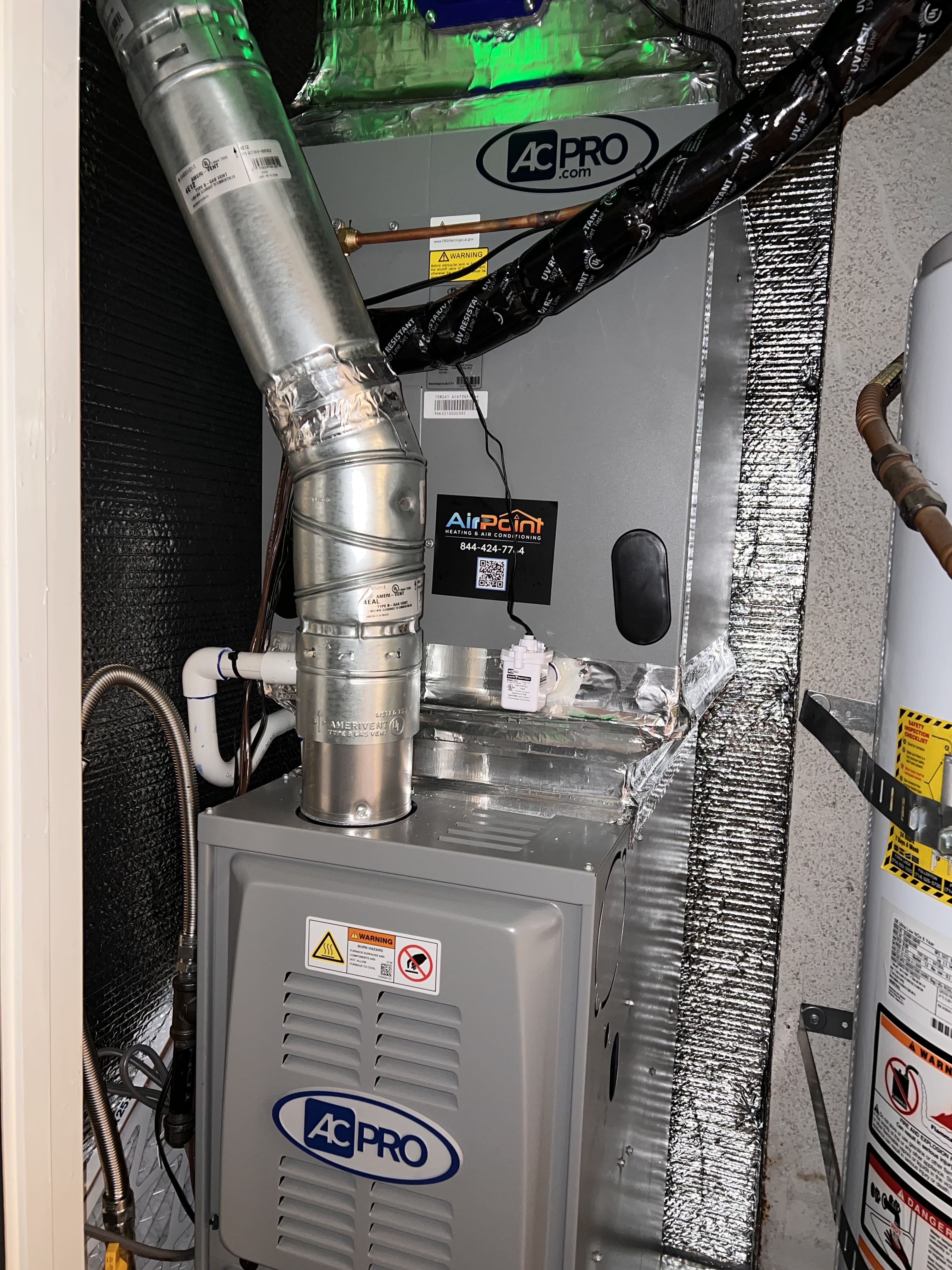 AC Pro air conditioning unit with metallic ductwork in utility room