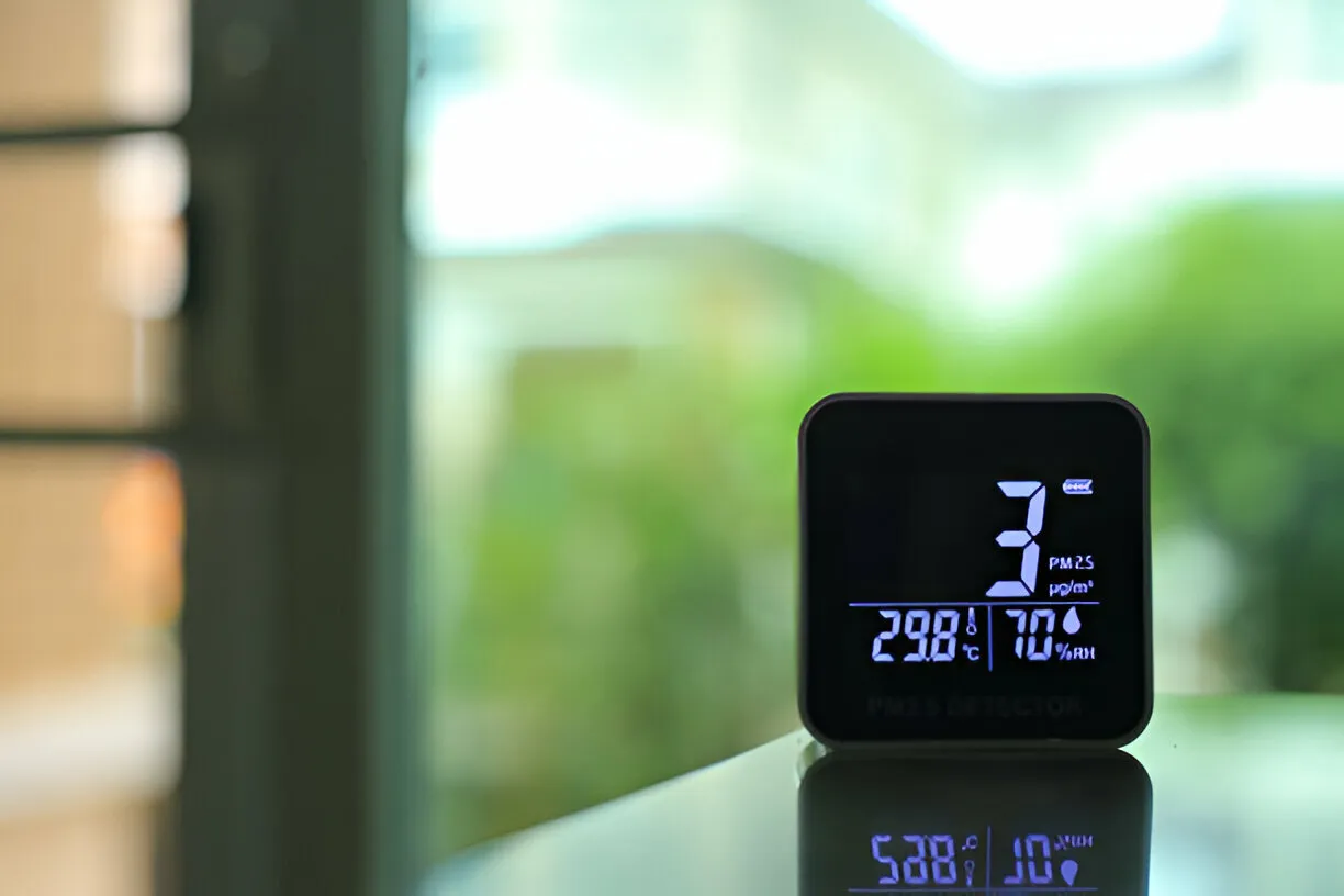 Digital air quality monitor showing temperature, humidity, and PM2.5 levels