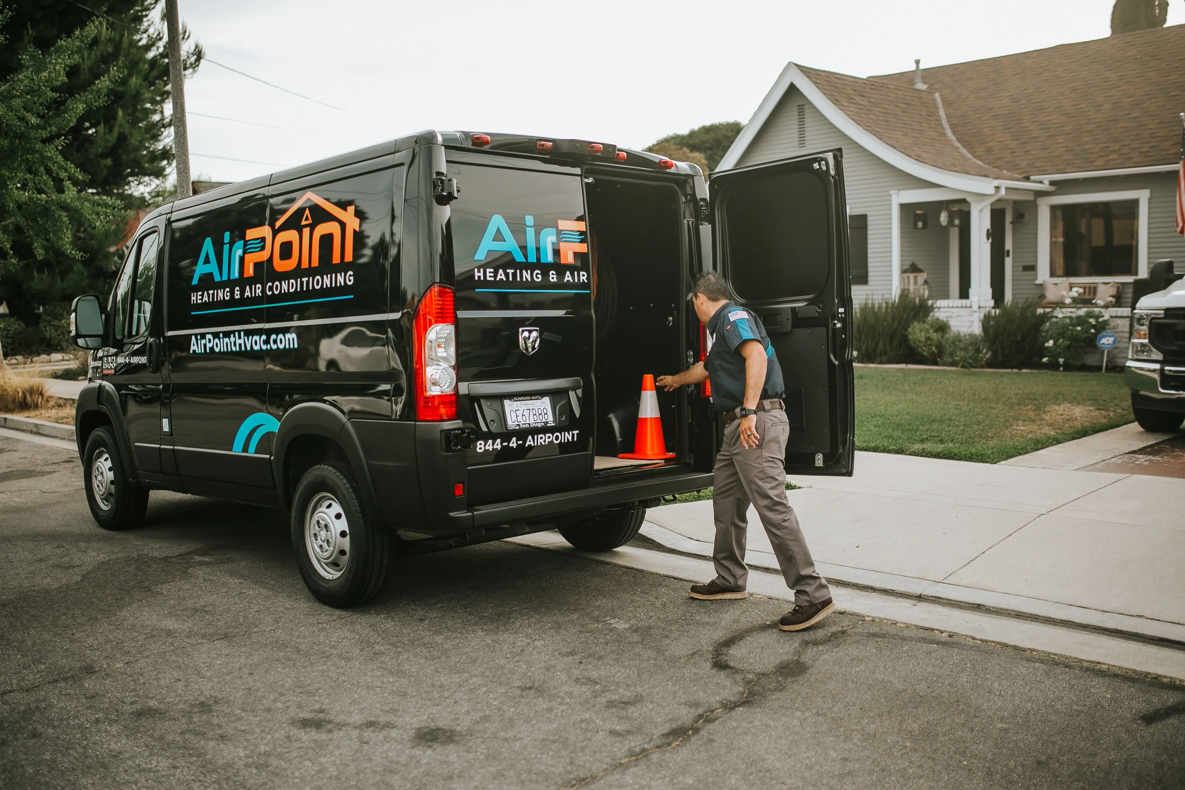 AirPoint HVAC service van parked on residential street with technician working