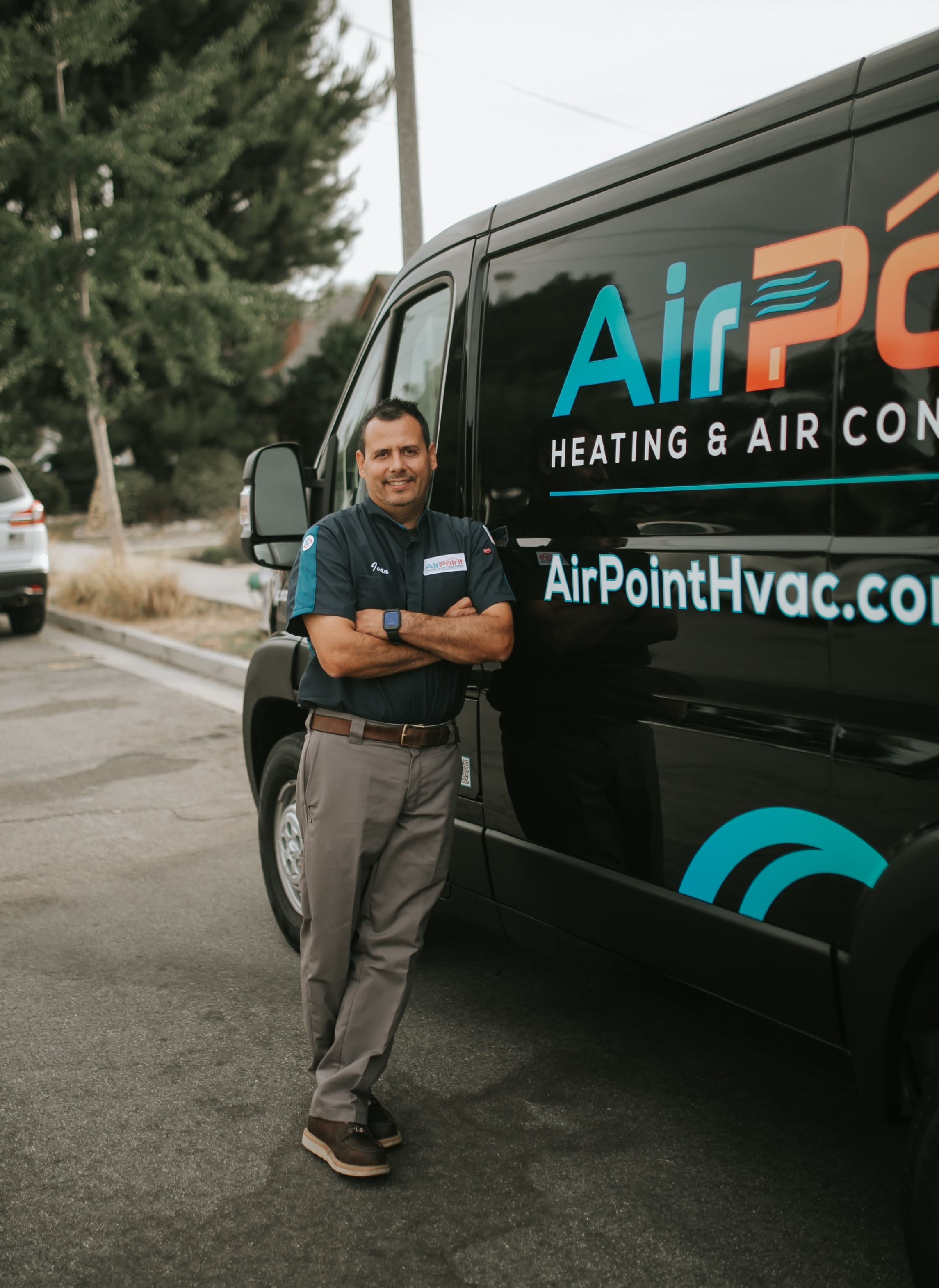 HVAC technician standing next to AirPoint service van on street