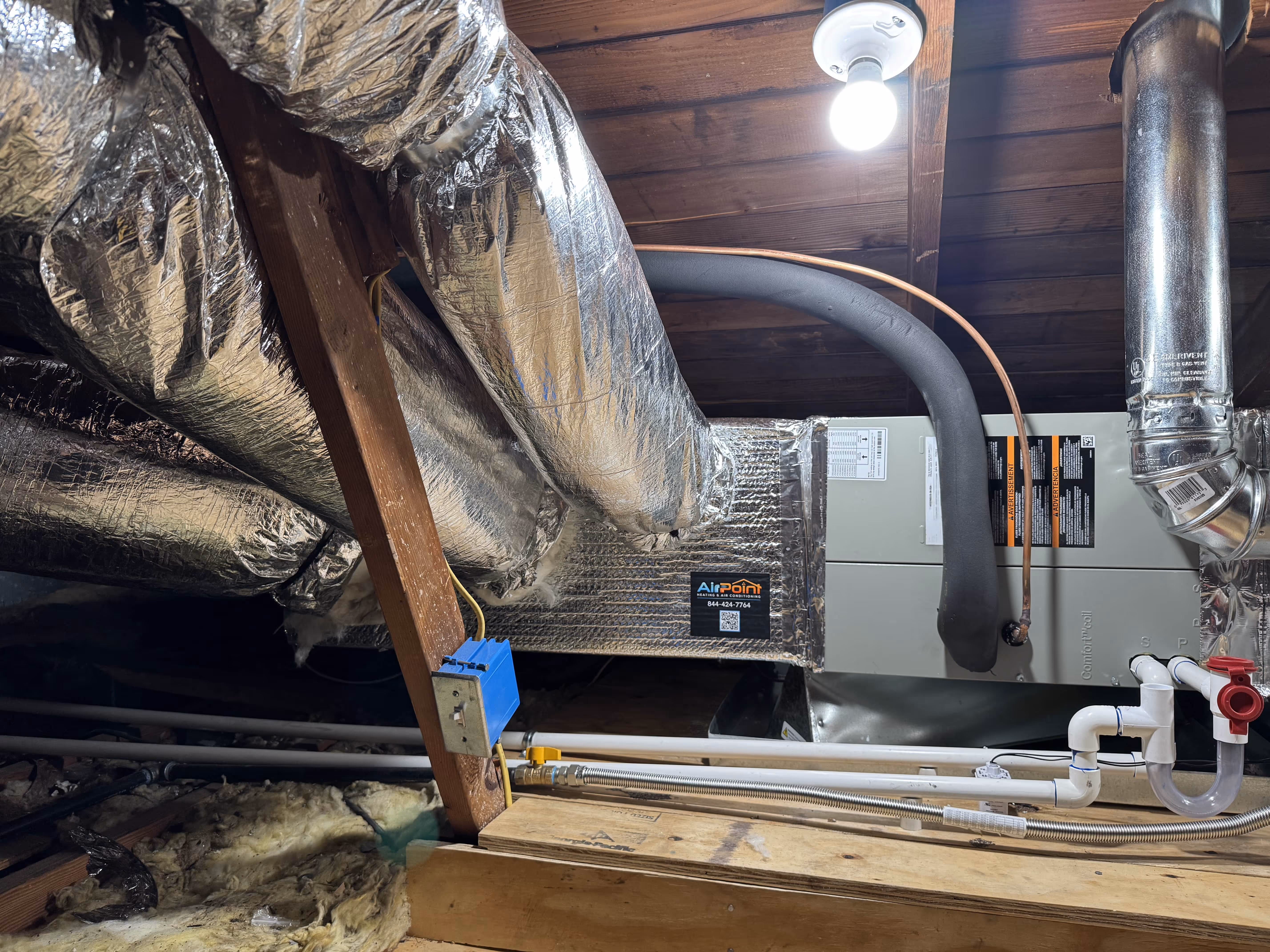 HVAC system with insulated ductwork and pipes in a wooden attic space