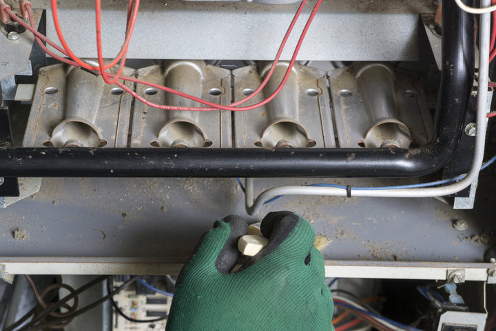 Gloved hand working on electrical components with red and white wires