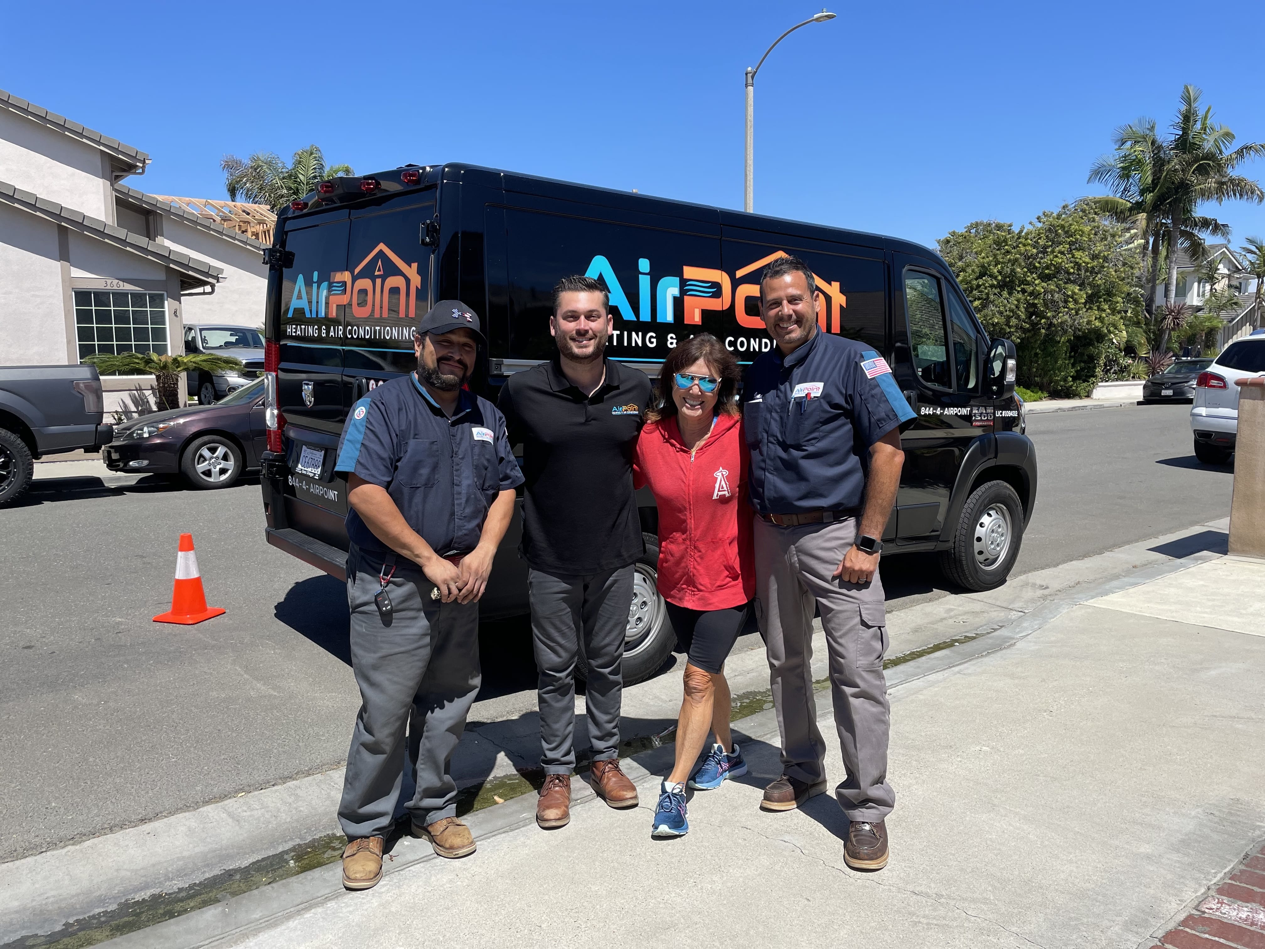 Four AirPoint Heating & Air Conditioning team members pose by service van