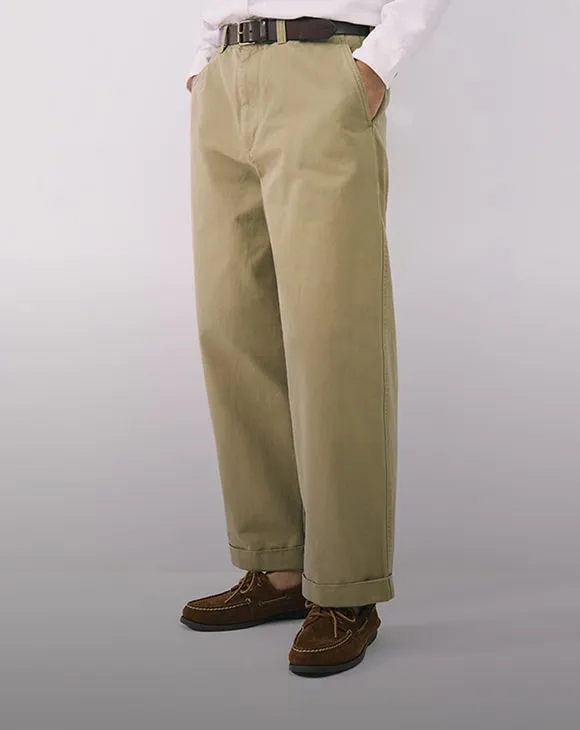 Man wearing khaki wide-leg pants from J.Crew, with a button prompting to find a more sustainable fashion alternative.