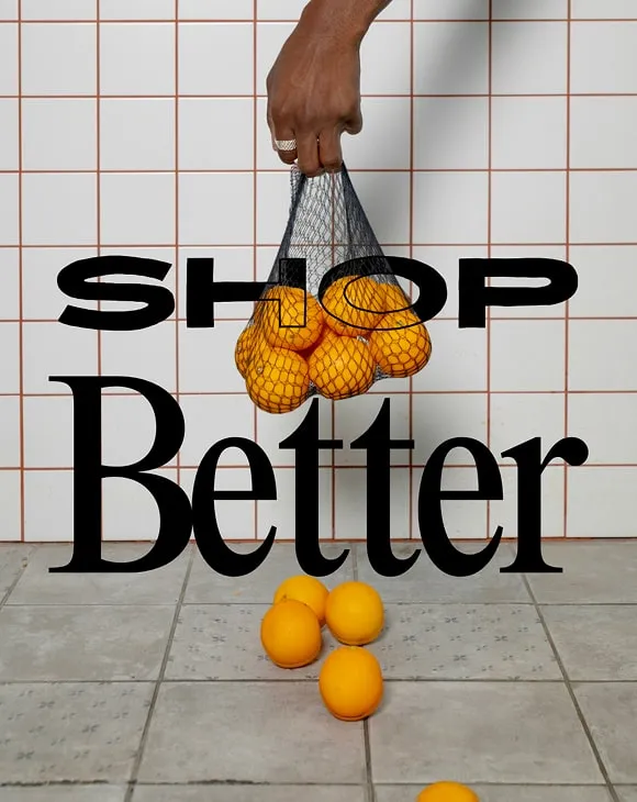 Hand holding a reusable net bag filled with fresh oranges, some rolling on tiled floor – eco-friendly shopping concept with bold "Shop Better" message.