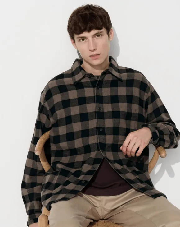 Uniqlo's new campaign features a man dressed in a stylish plaid shirt, highlighting contemporary fashion trends.
