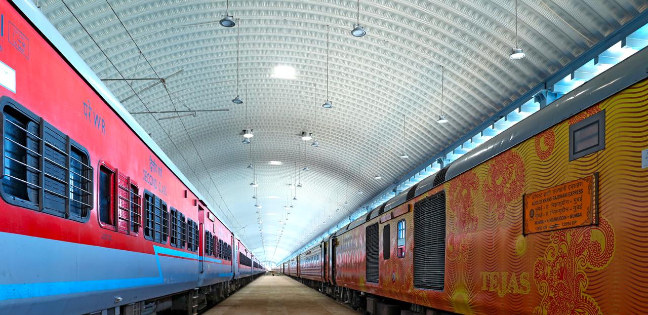 Train shed interior with arched roof and colorful trains
