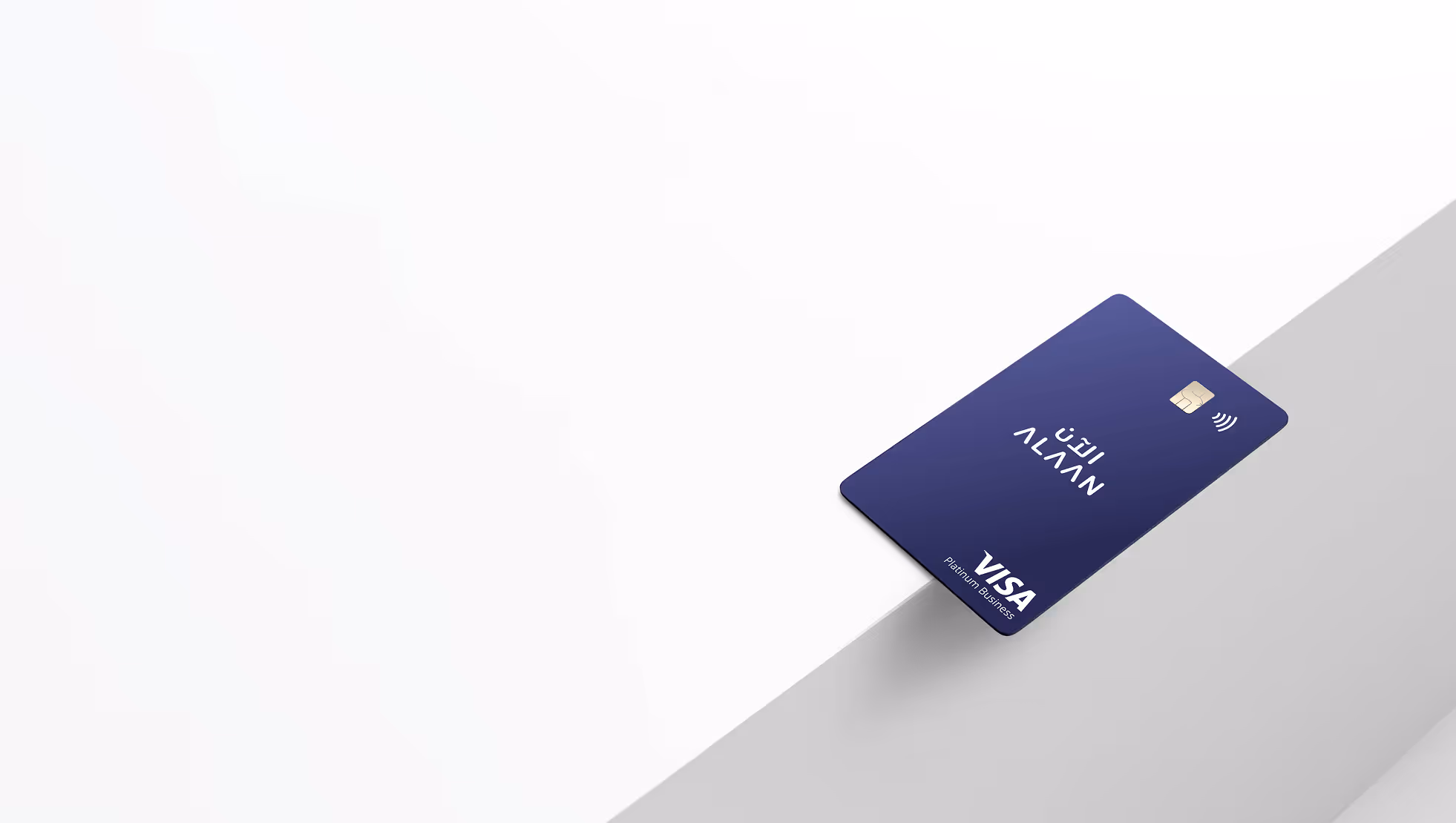 Navy blue Alaan Visa Platinum Business card with contactless payment symbol, displayed on a white and gray surface.