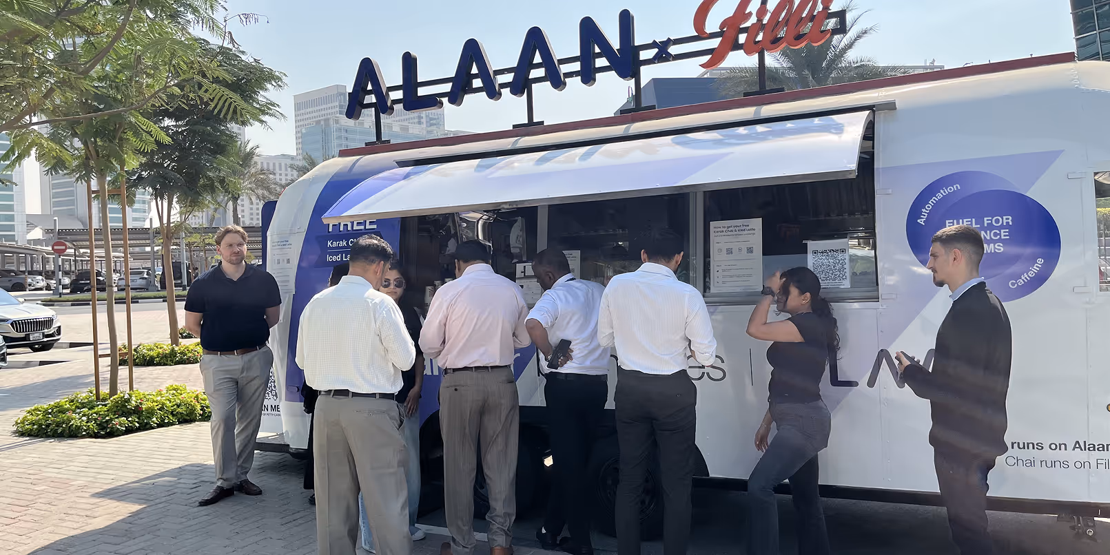 People standing in line ordering from a white and blue food truck