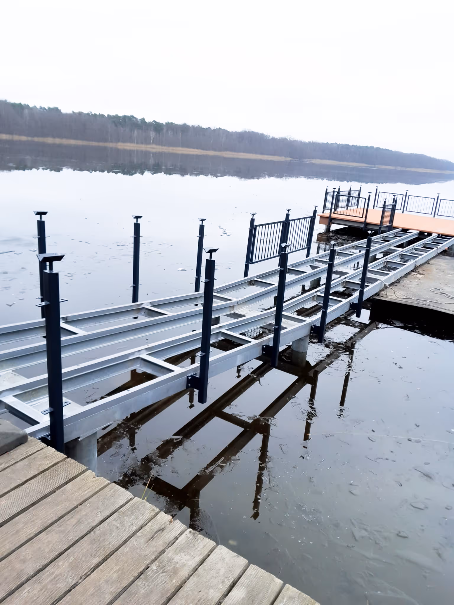Präzise Montagearbeiten an einer Anlegestelle mit Stahlträgern und Holzauflage