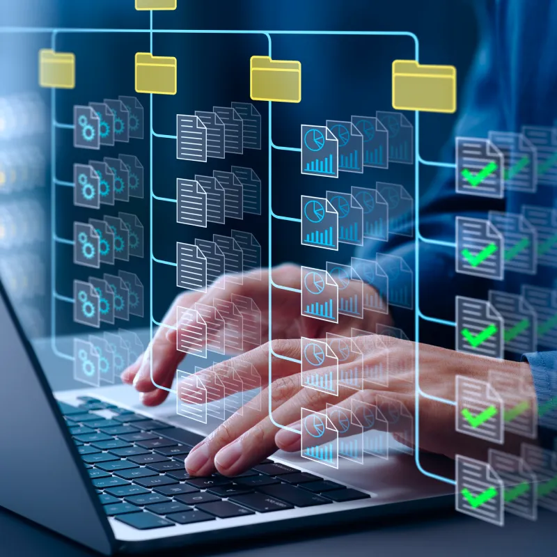 Person typing on a laptop keyboard with a digital overlay of interconnected folders and files representing data organization and workflow.