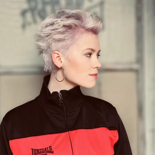 Zufriedene Kundin nach Friseurbesuch bei Glow Stories Hannover.