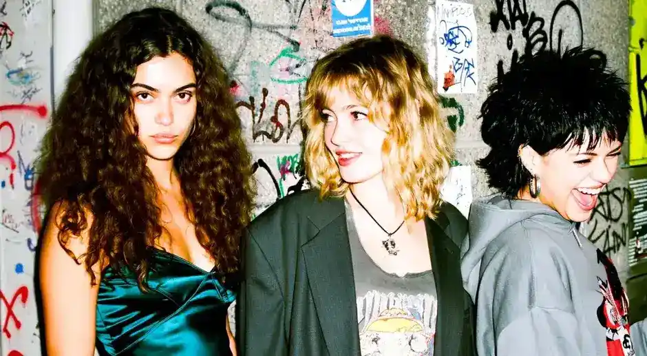 Drei Kundinnen mit stylischen Frisuren vor Graffiti-Wand im Glow Stories Salon Hannover Linden.