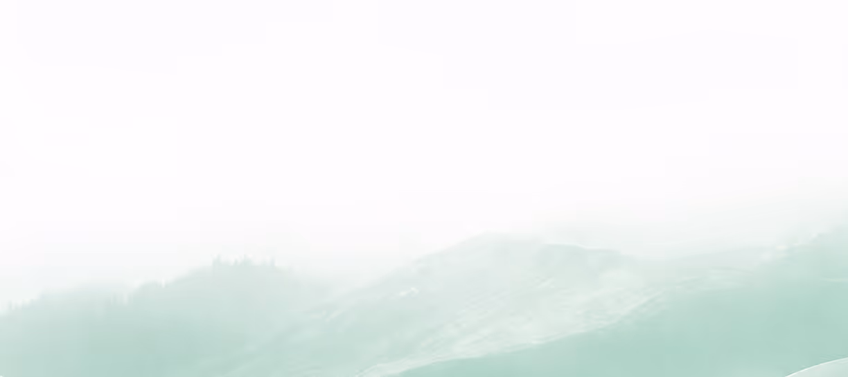 Soft green and white misty mountain landscape fading into a white sky.