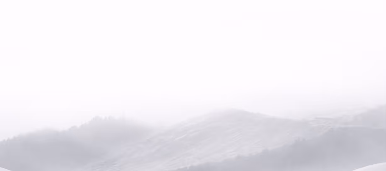 Mist-covered rolling hills blending into a pale sky.