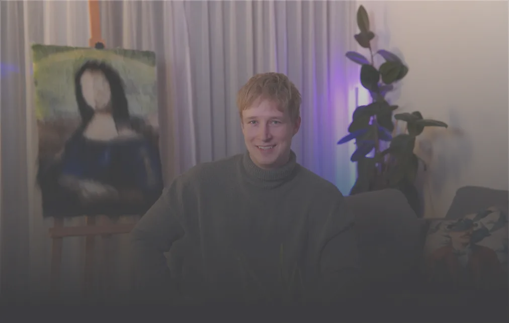 Man with blonde hair and tattoos sitting inside a boxing ring with red and blue ropes.