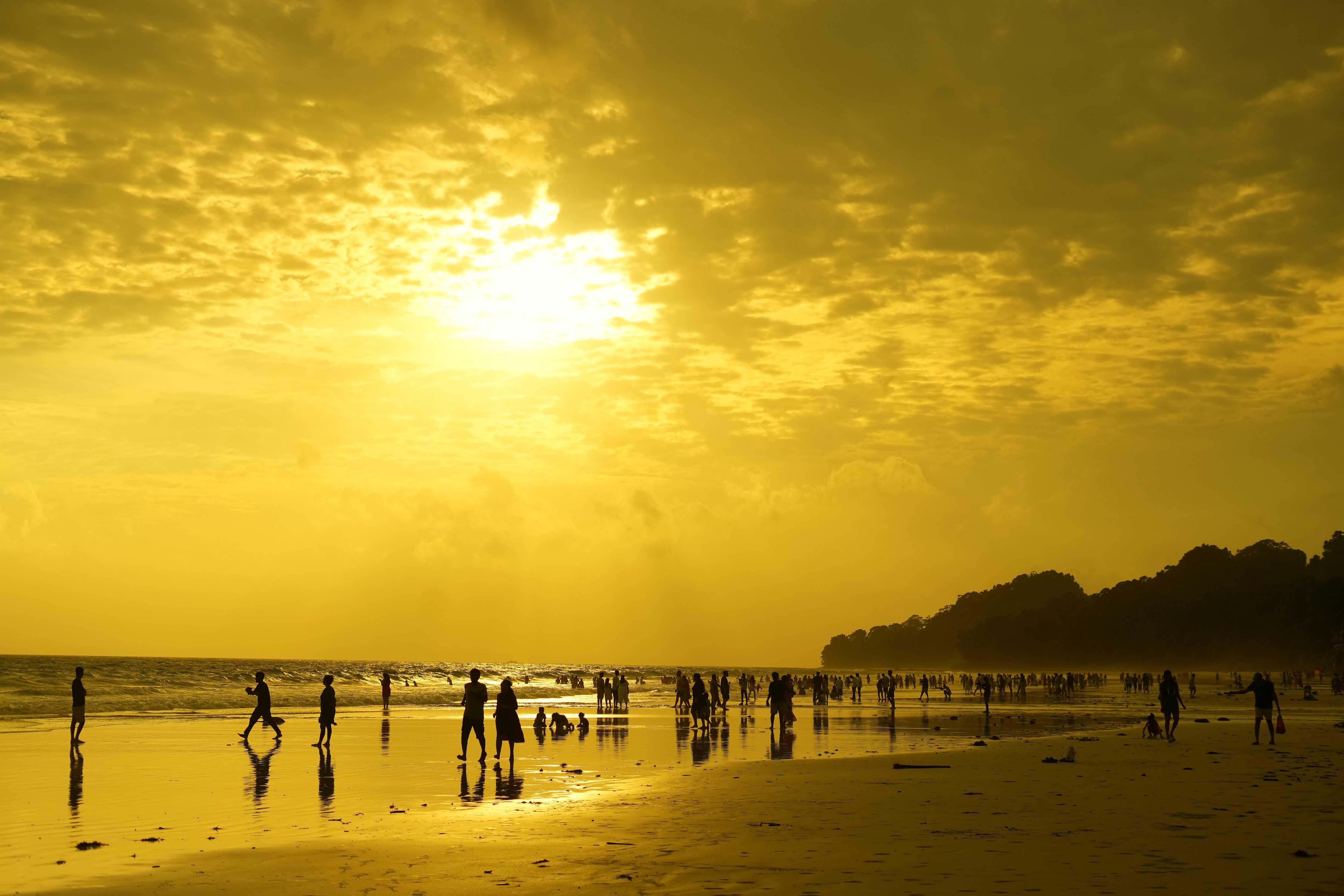 Sunset beach setting with people in silhouette, illustrating the human-centred appraoch to team offsites in 2025