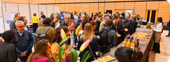 Foule en train de se servir à un buffet dans une salle de conférence.