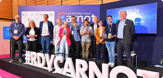 Groupe de dix personnes sur scène aux rendez-vous Carnot avec un hashtag #RDVCARNOT en avant.