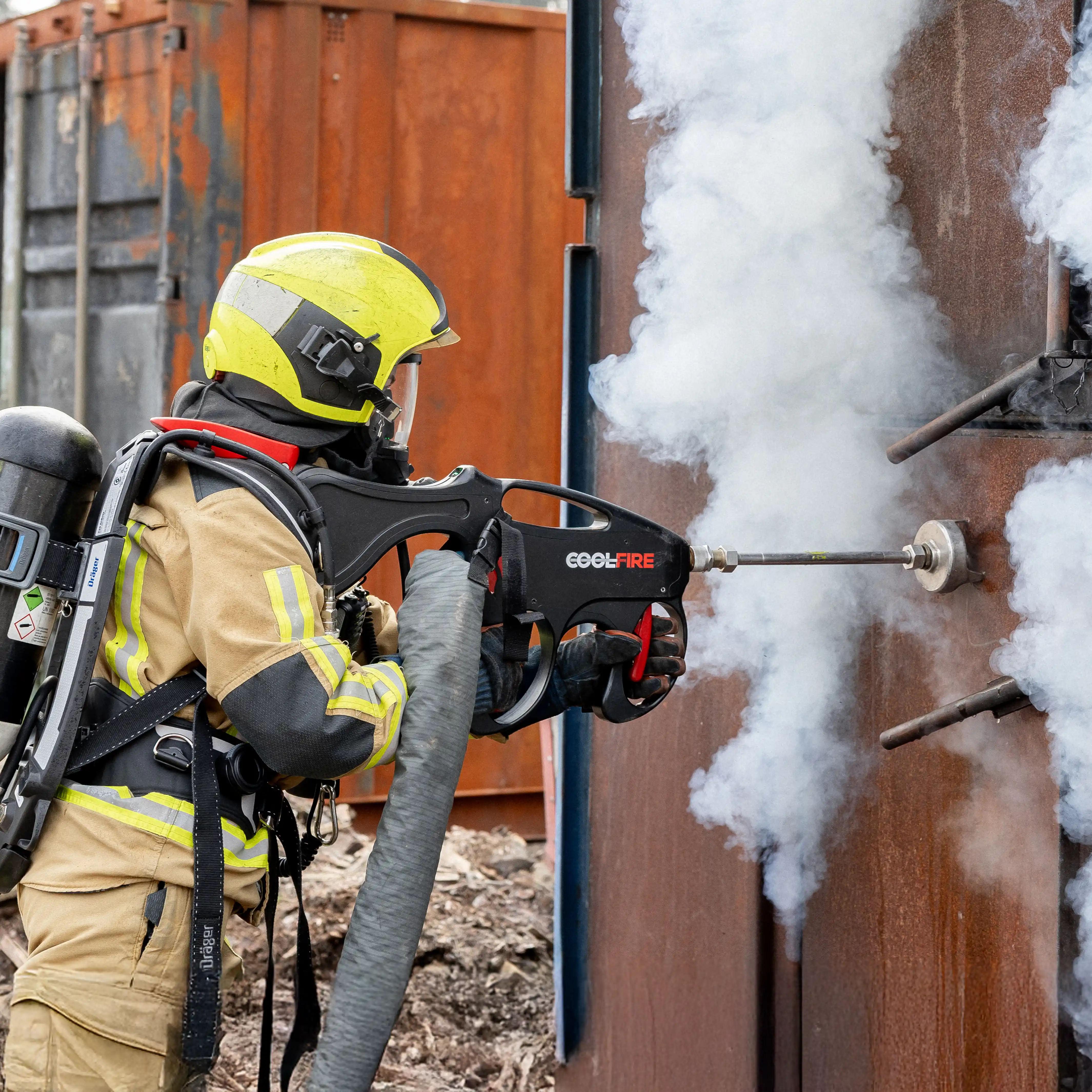 Brandweerman oefent met de Coolfire-lans tijdens een opfristraining. De krachtige waterstraal doorboort een metalen wand en koelt direct de rookgassen, zonder het compartiment te betreden – een essentiële techniek voor veilige inzet.