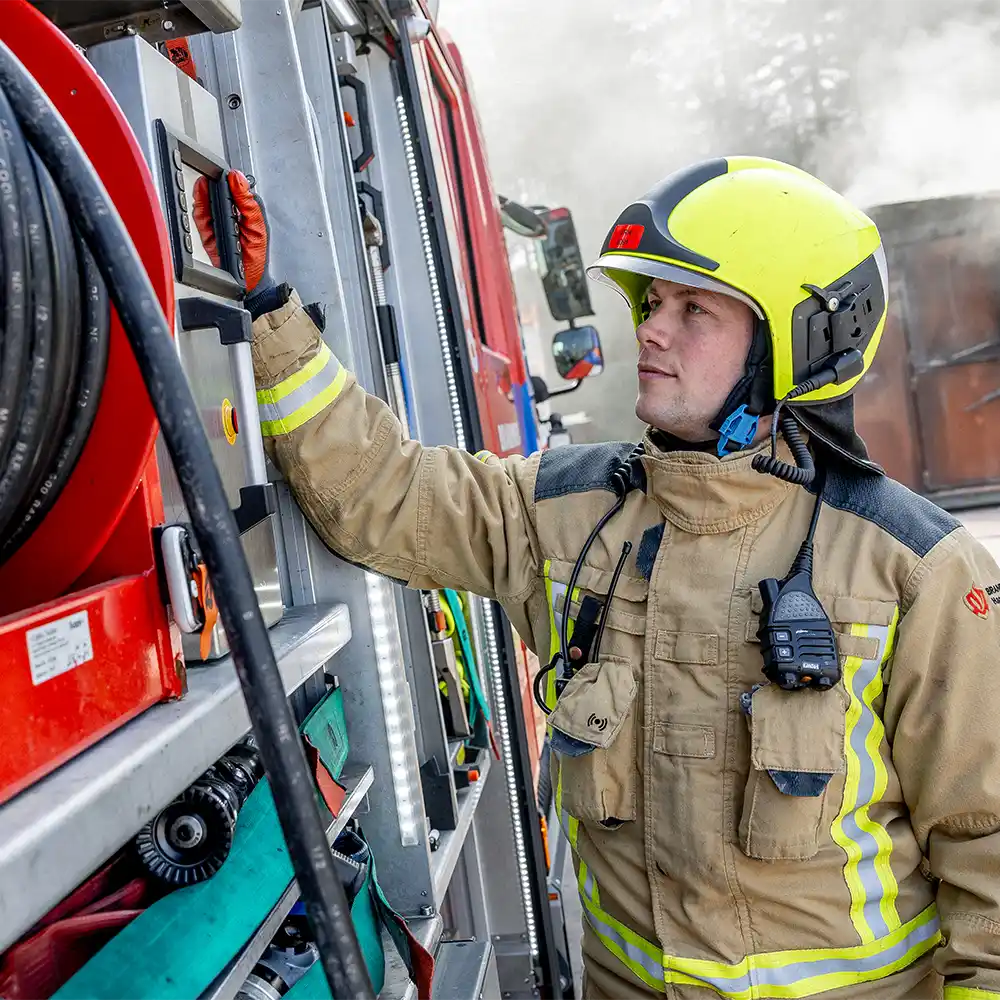 Brandweerman bedient de systemen in een blusvoertuig tijdens een Coolfire-inzet. De slimme indeling en directe toegang tot de slanghaspel en gereedschappen ondersteunen een snelle, veilige en gecontroleerde aanpak van brandbestrijding.