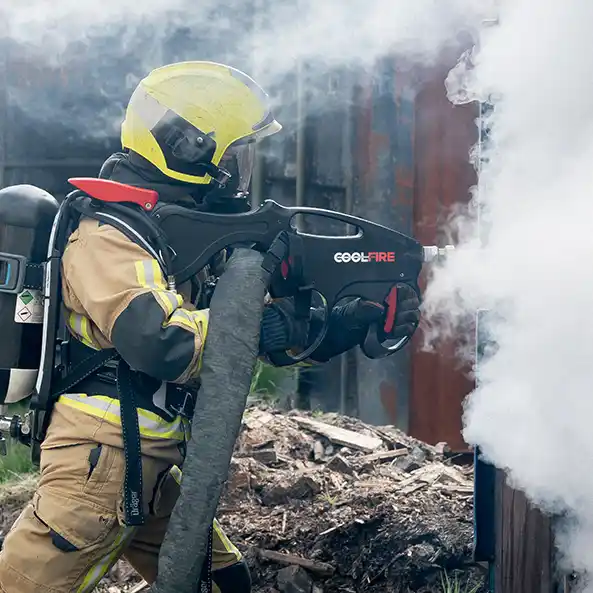 Brandweerman gebruikt de Coolfire-lans om rookgassen te bestrijden via een gesloten wand. De krachtige, gerichte nevel toont de cutting-edge technologie van het systeem voor snelle, veilige en geavanceerde brandbestrijding.