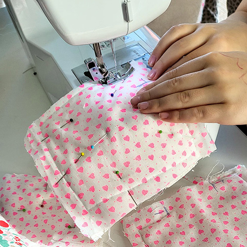 Enfant travaillant sur la machine à coudre avec du tissus