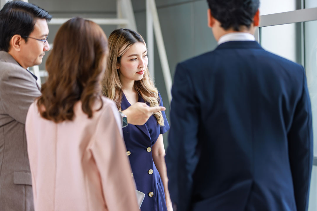 A business man pointing at a window standing in a group of business people. Start2 Pilot program image.
