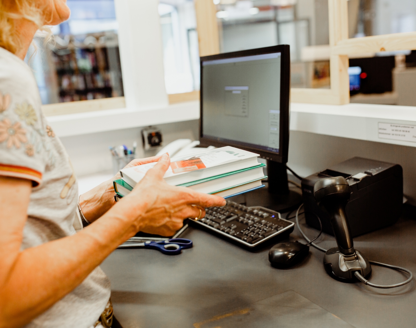 Dame met boeken voor een scansysteem