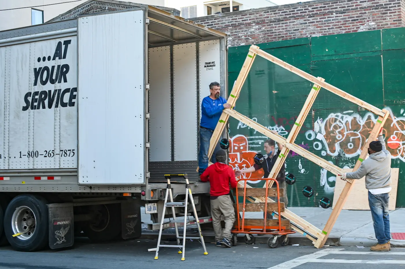 a man standing on a truck with a wooden frame
