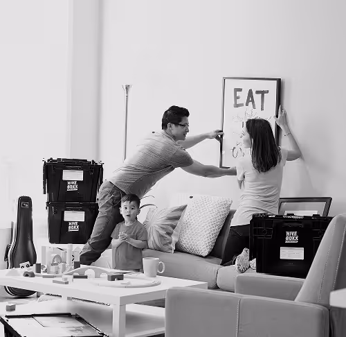 image en noir et blanc d'un couple qui accroche une affiche au mur