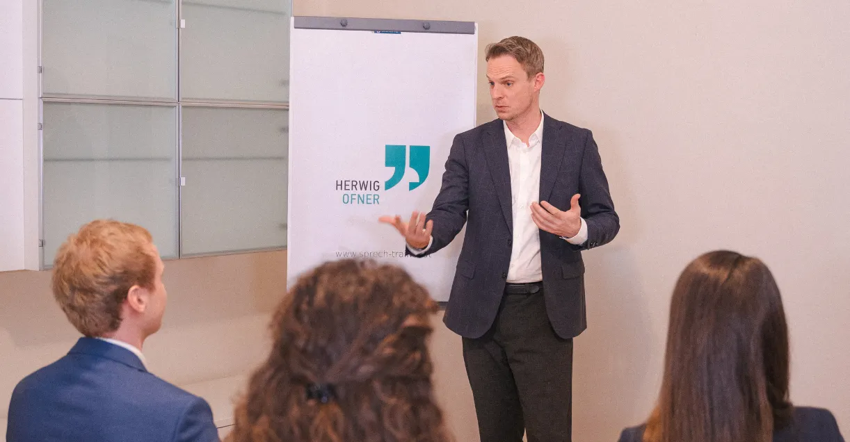 Herwig Ofner beim Sprechtraining in Wien, präsentiert vor Publikum am Flipchart