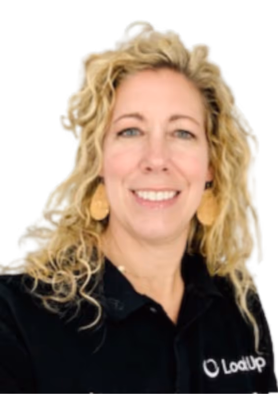 Smiling woman with curly blonde hair wearing round earrings and a black LoadUp polo shirt.