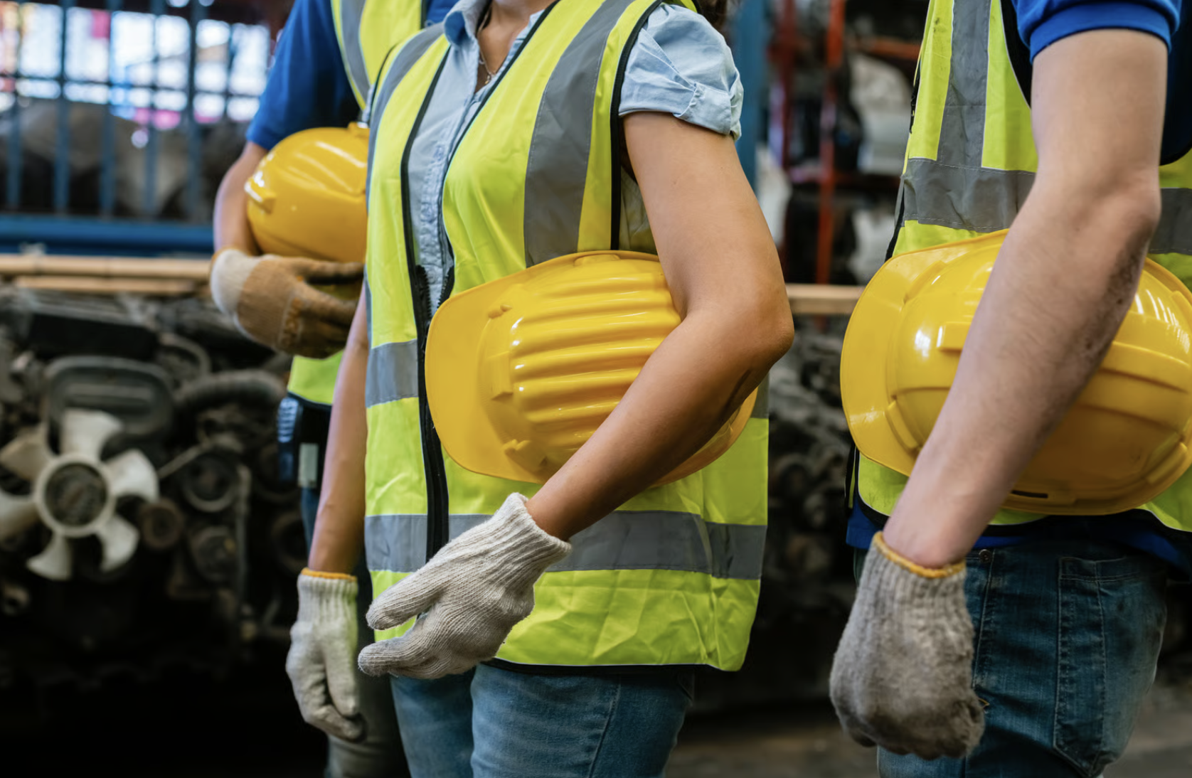 A close-up of hard hats worn by a team of blue-collar workers.