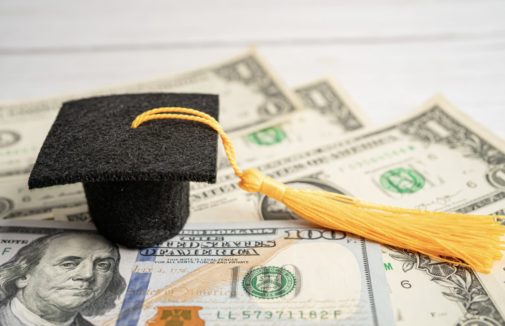 Graduation gap hat on US dollar banknotes money, Education study fee learning teach concept.