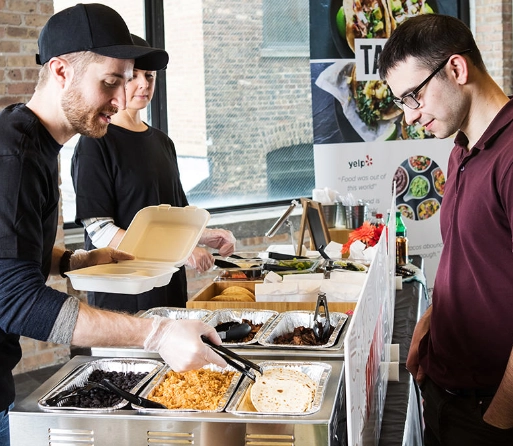 Photo of a Fooda Popup where you can see the restaurant worker creating a meal for the customer