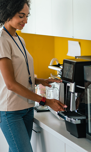 woman using an automatic coffee machine