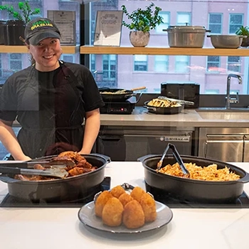 A smiling restaurant worker ready to serve at a Popup
