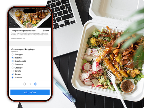 Smartphone screen shows ordering on the Fooda app beside an open salad container.