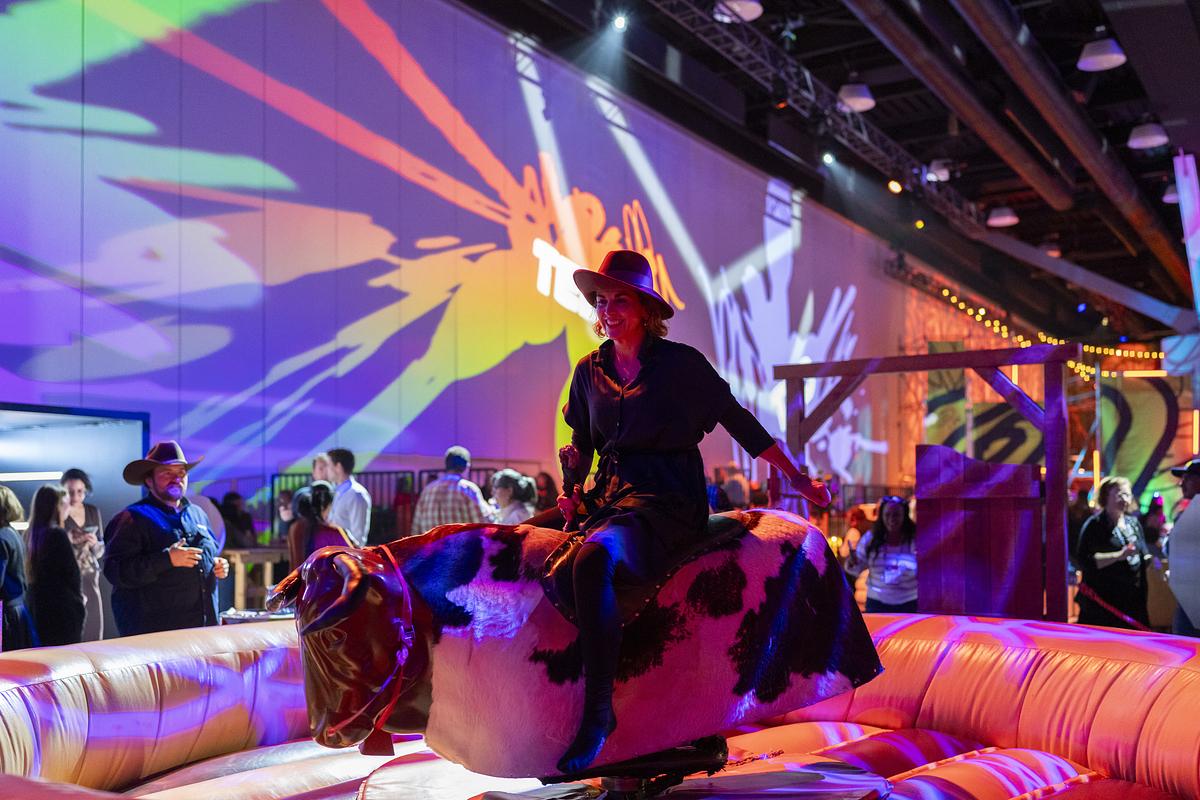 ted2026-a person in a cowboy hat riding a mechanical bull at TED party-parties and receptions