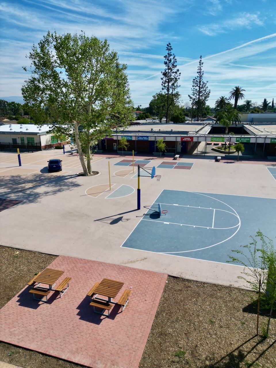 Cortada Elementary after renovation: landscaped campus with mature trees and native plantings.